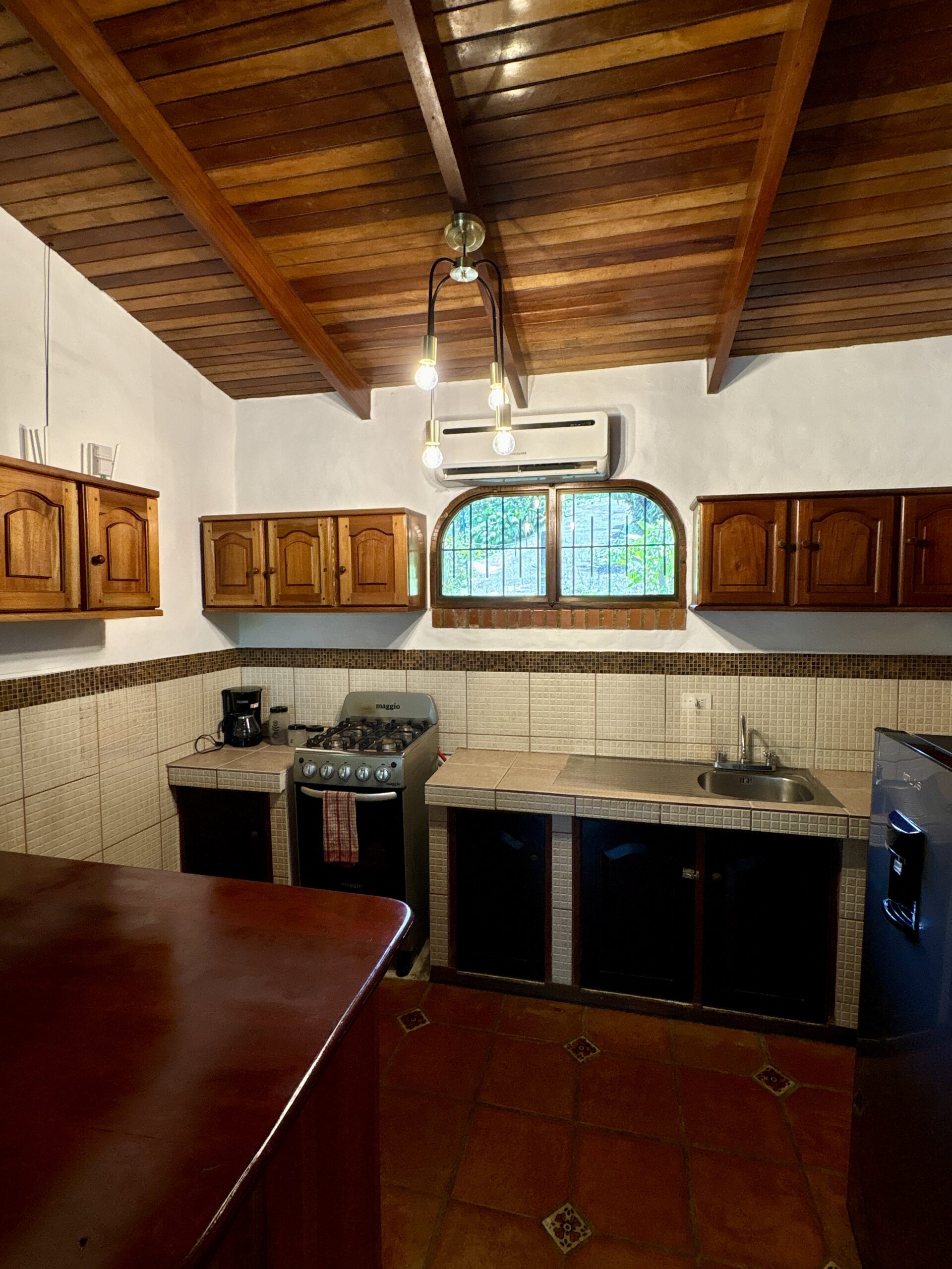Full kitchen inside a villa surrounded by rainforest views