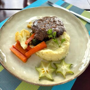 Juicy grilled steak served with fresh sides at Planeta Sano Restaurant in Manuel Antonio.