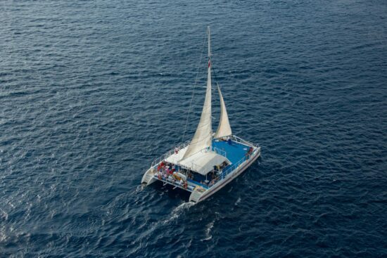 Catamaran sailing along the blue waters of Quepos with guests enjoying the ocean views and sunshine.